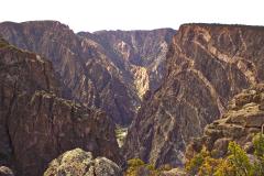 A chasm view of the pink-veined cliffs and the Gunnison River below at Black Canyon of the Gunnison National Park