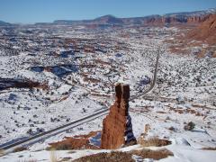 A snowy, elevated view looking down upon Chimney Rock and the road through Capitol Reef National Park