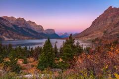 Morning colors of pink and blue mixed with autumn colors of gold and red at the Wild Goose Island view area on St. Mary Lake, Glacier National Park