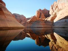 Red-rock erodional knobs and hills reflected in the water of Lake Powell at Glen Canyon National Recreation Area