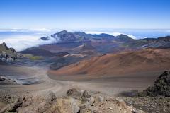 A wide-angle vista of clouds, cinder cones and other volcanic scenery in Haleakala National Park in Hawaii