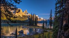 The small landscape known as Spirit Island, surrounded by mountains and forests lining the shores of Maligne Lake in Jasper National Park.