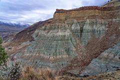 Layered green and pink soils capped by a layer of basalt at the end of the Flood of Fire Trail at John Day Fossil Beds National Monument