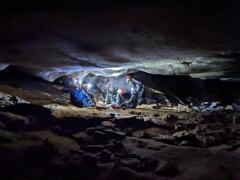 Group of cavers sitting in passageway with headlamps on, Mammoth Cave National Park
