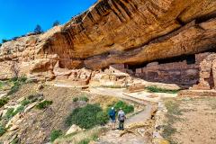 A park ranger and tourist viewing Long House cliff dwelling ruins in Mesa Verde National Park in Colorado