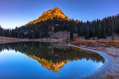 A reflection of a mountain with the sunrise bathing the top of the mountain peak at Tipsoo Lake, Mount Rainier National Park