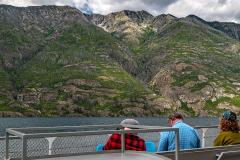 A view of ferry goers enjoying the mountain scenery along the shore of Lake Chelan National Recreation Area in Washington state