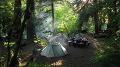 Tents set up and acampfire going in a shady area of Sol Duc Campground, Olympic National Park