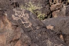 A petroglyph of a dancing ceremonial figure or god etched into the rock at Petroglyph National Monument, in Albuquerque, New Mexico