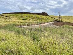A grassy field with a trail leading to a temple built by a Hawaiian king at Pu'ukohola Heiau National Historic Site 