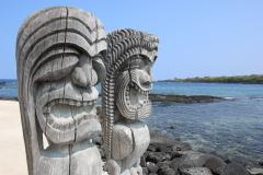Two Ki'i statues guarding the royal grounds of Puʻuhonua o Hōnaunau National Historical Park
