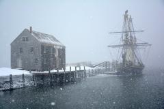 A replica of the ship Friendship docked in the water during a snowstorm, Salem Maritime National Historic Site