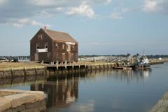 A historic building and wharf with tugboats at Salem Maritime National Historic Site