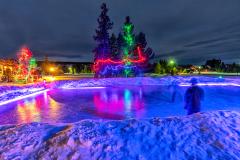 A purple-lit ice rink surrounded by snow and Christmas lights, Yellowstone National Park